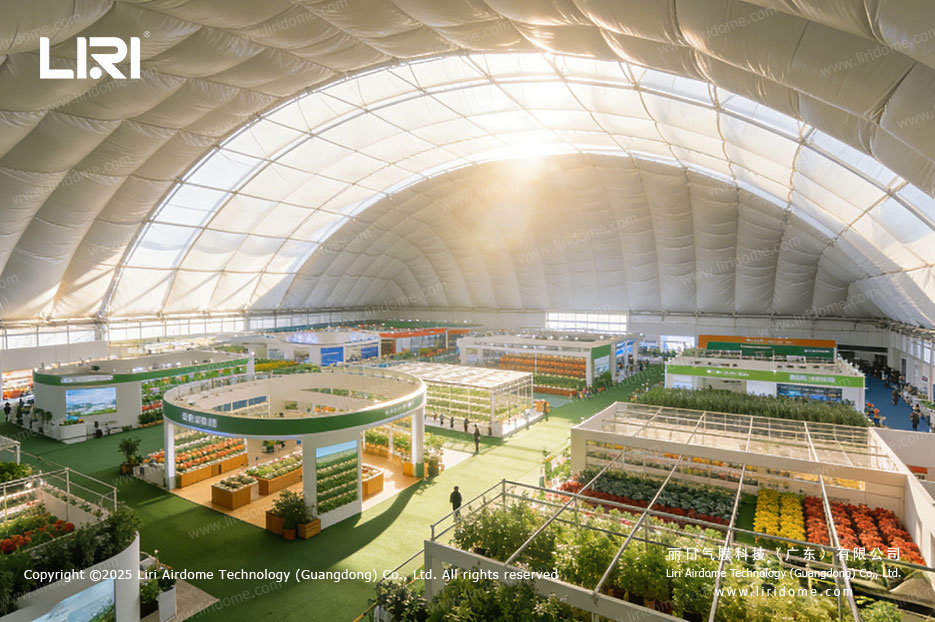 Large air dome agricultural exhibition hall with green display booths and potted plants