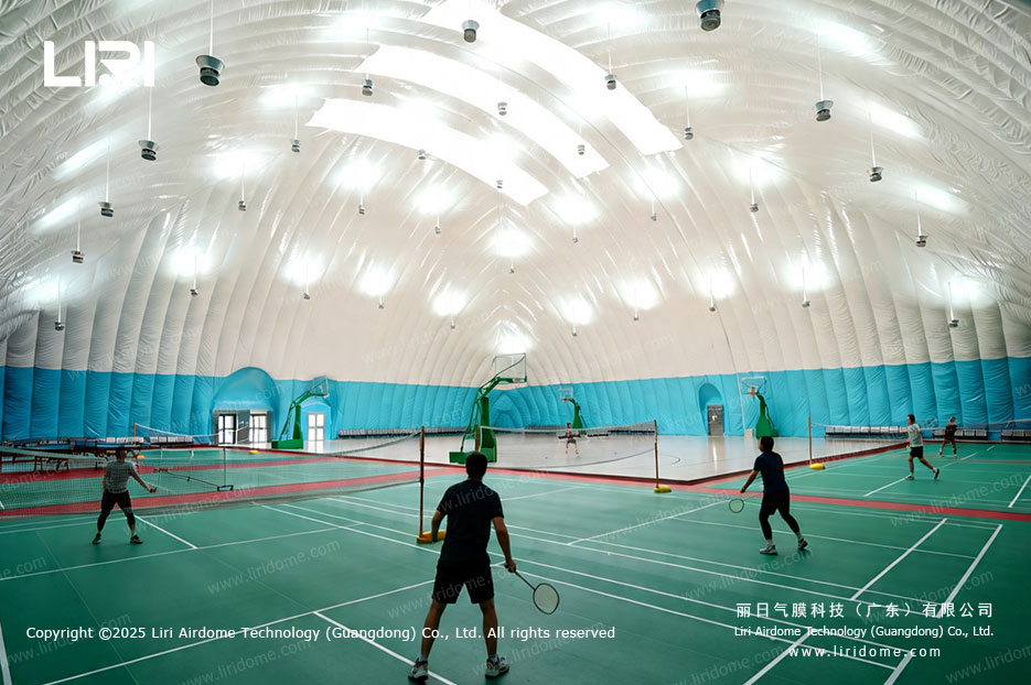 Interior of Liri air dome venue with players using badminton courts under the inflated membrane