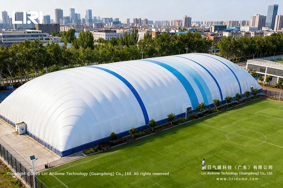 Aerial view of a white football air dome beside an outdoor pitch