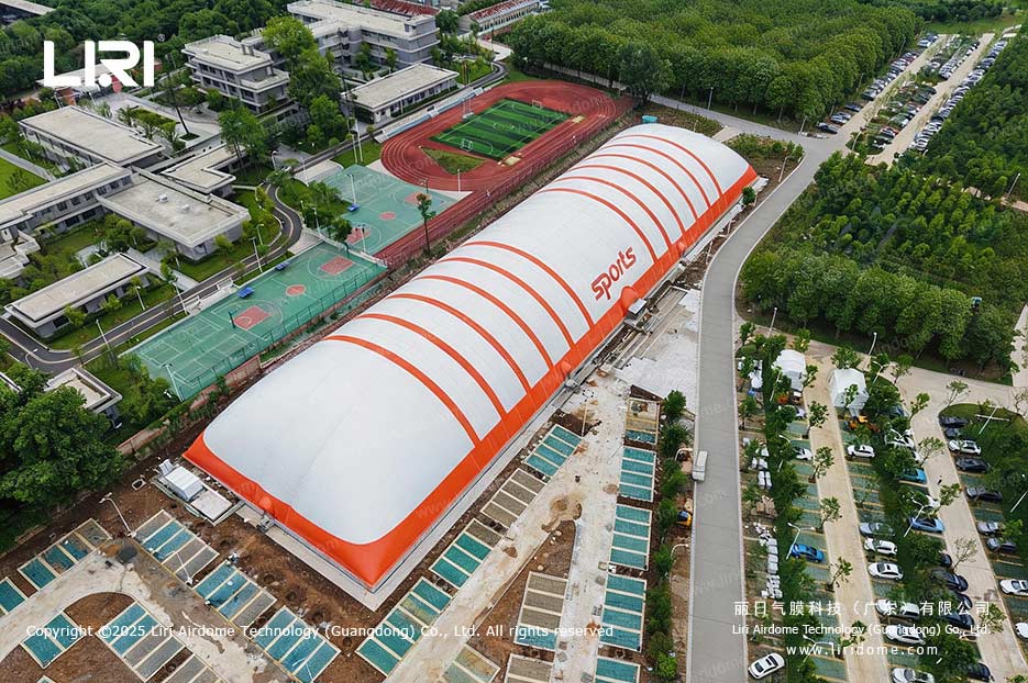 Top view of an air dome gymnasium roof next to campus basketball courts