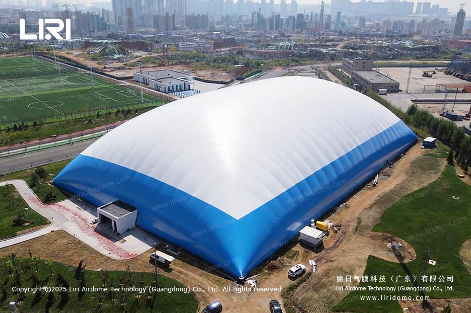 Blue and white football air dome on a large open site seen from above