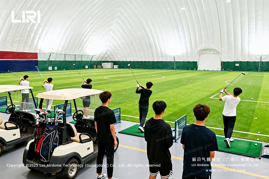 Indoor golf practice area inside a large air dome sports venue