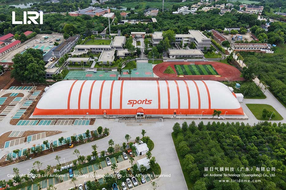 Aerial view of a school sports air dome gymnasium beside the campus running track