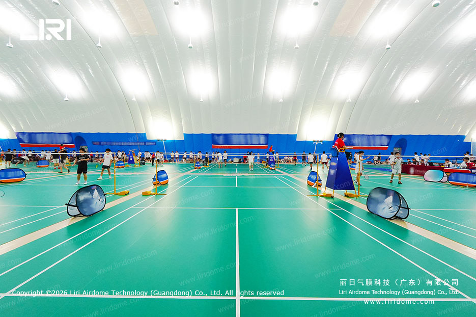 Central badminton courts inside a spacious school air dome gymnasium