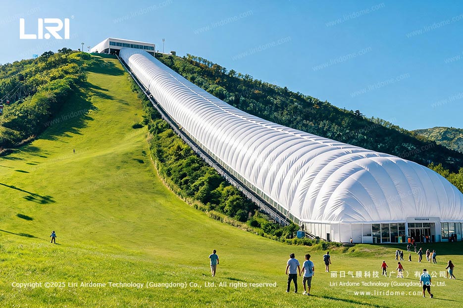 Long hillside air dome enclosing an indoor ski slope